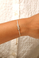 Adjustable anti-tarnish bracelet with elegant bow design.