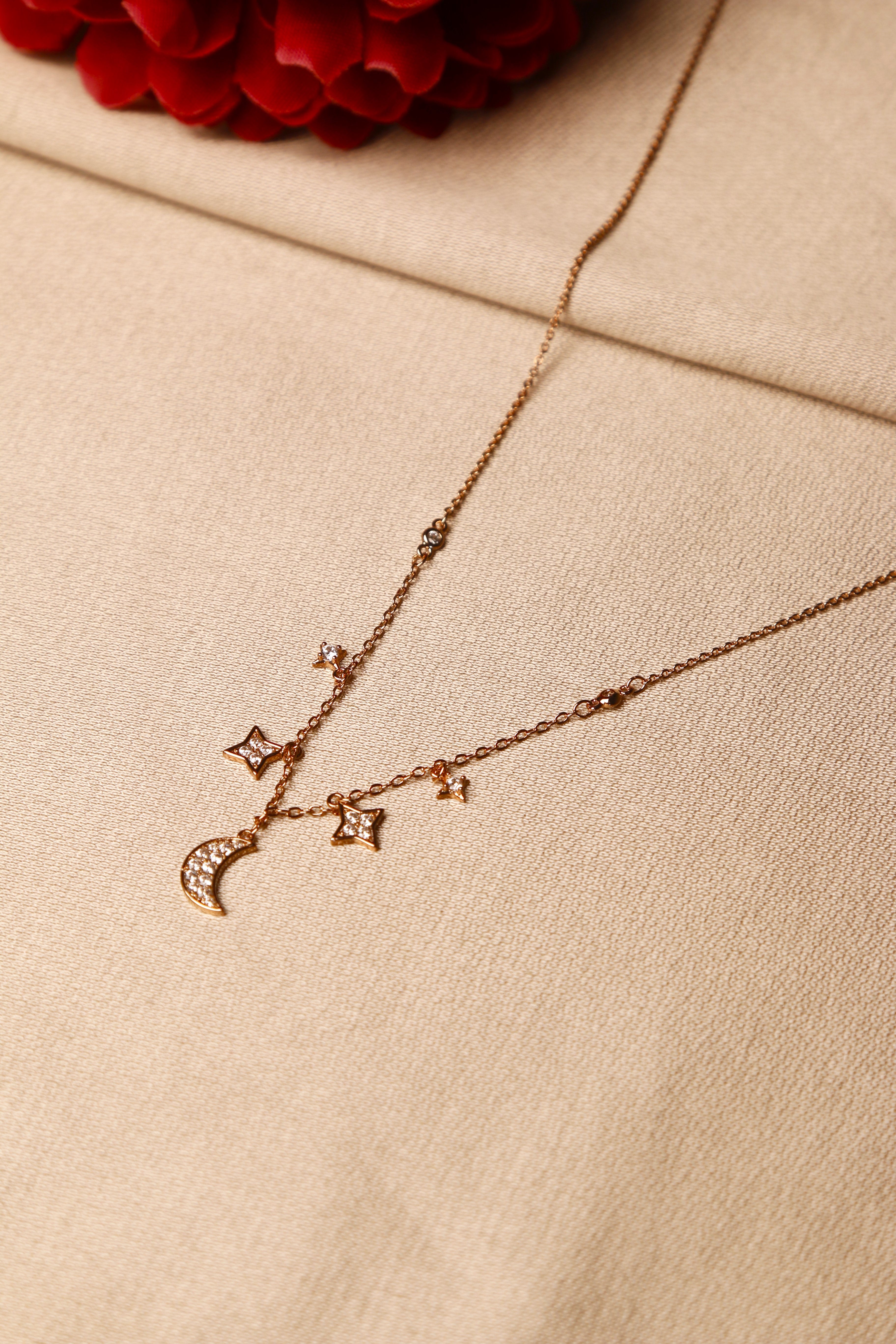 A delicate gold necklace with a crescent moon pendant.