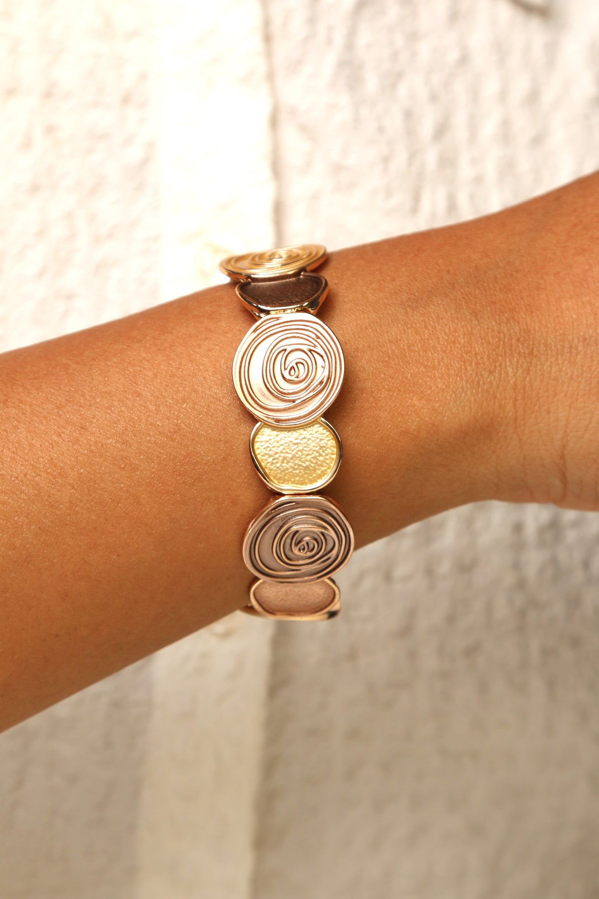 Tri-tone disc bracelet with gold, rose gold, and bronze hues.
