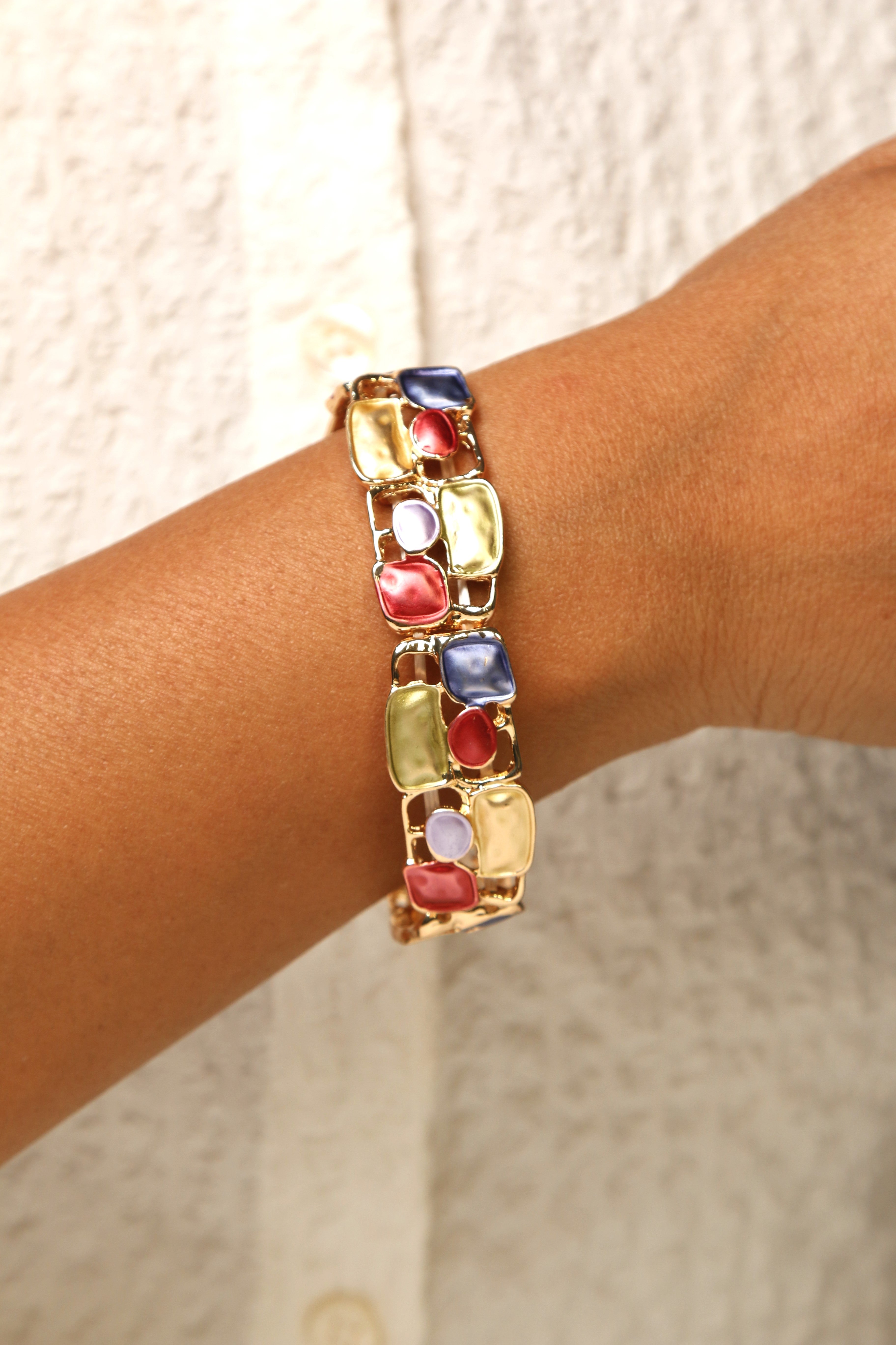 Multi-colored mosaic stretch bracelet with gold-tone finish.