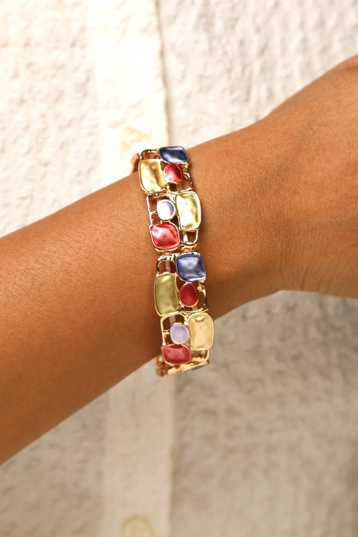 Multi-colored mosaic stretch bracelet with gold-tone finish.