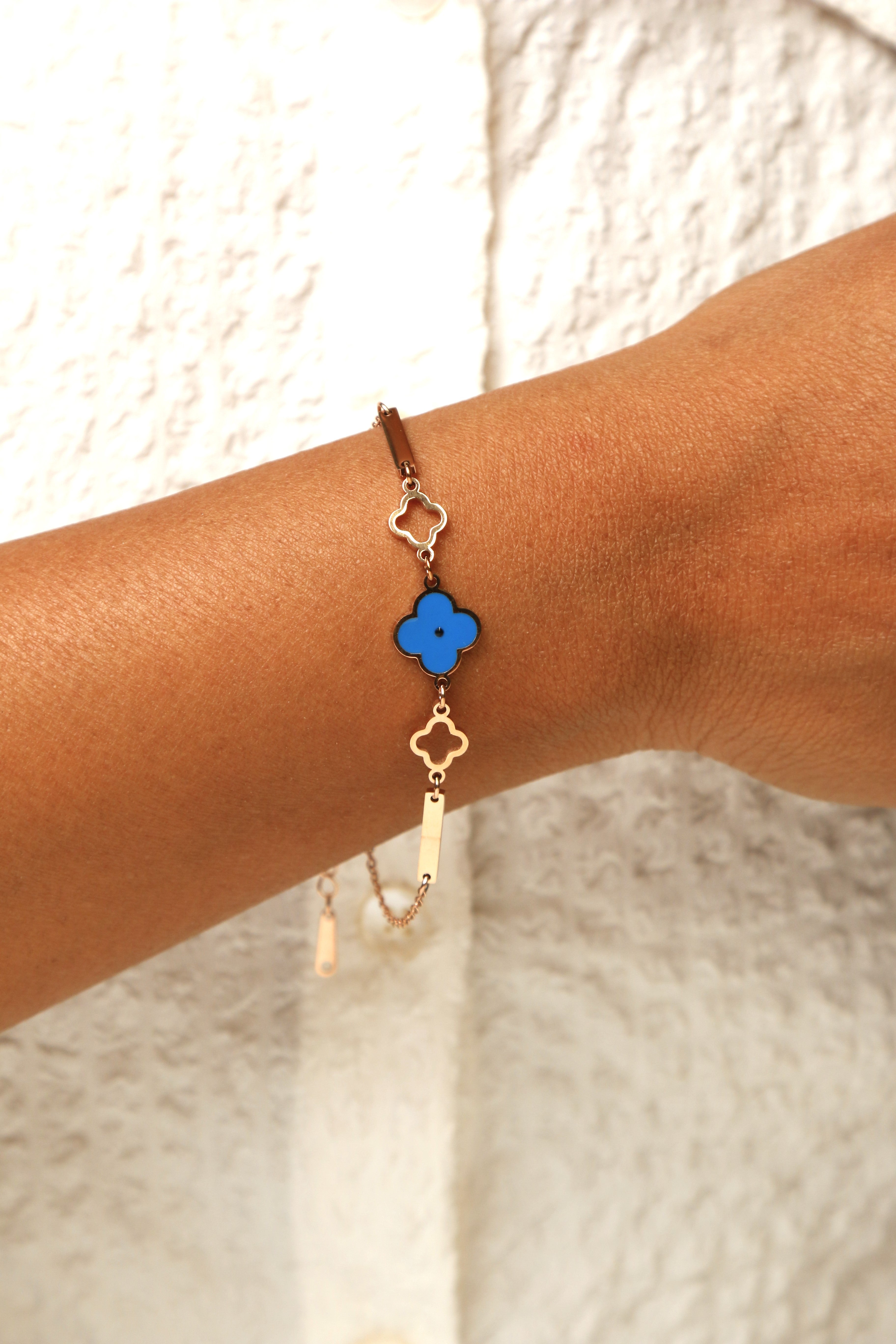 Blue clover charm bracelet with a rose gold-tone chain.