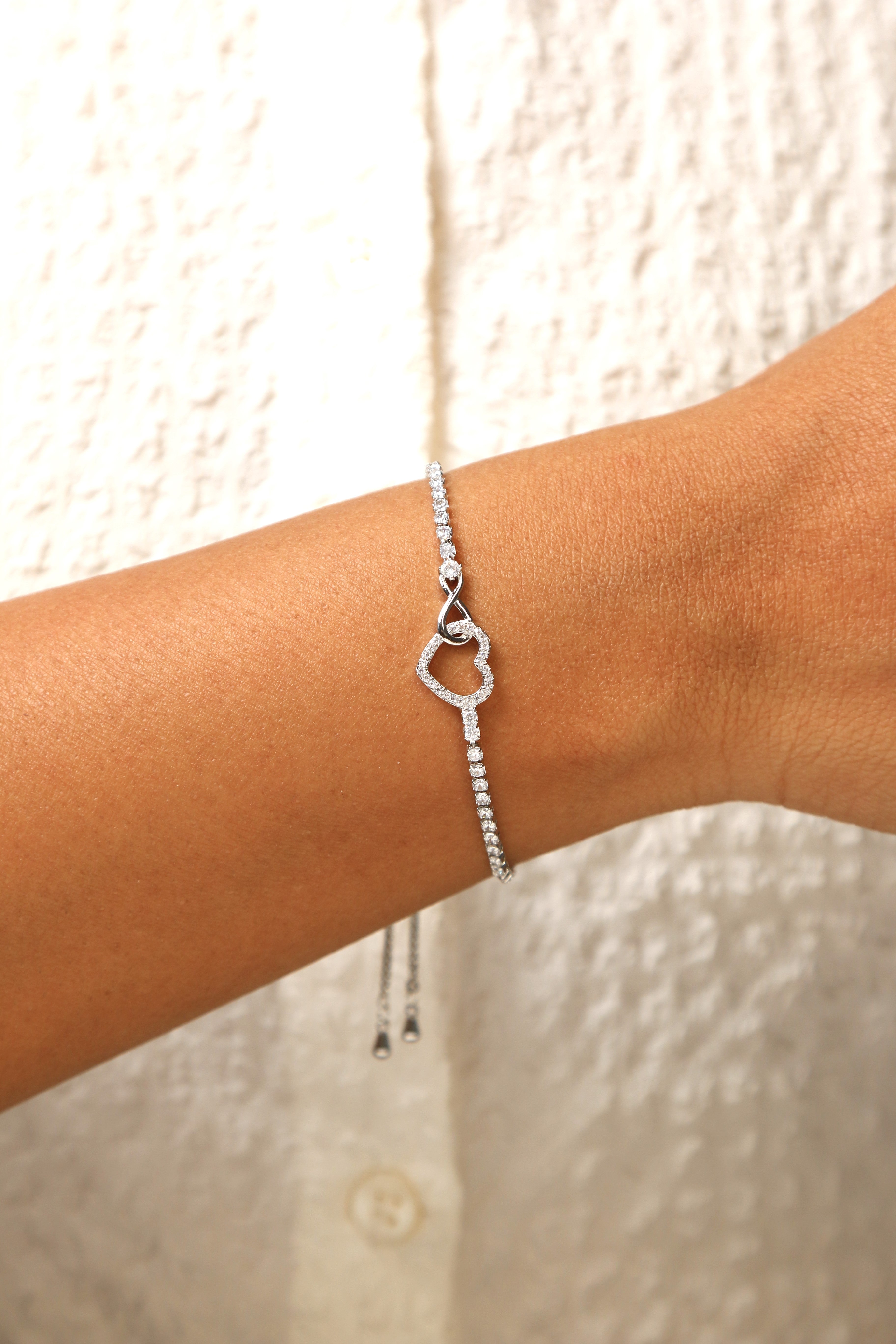 Delicate heart charm bracelet with an adjustable chain.