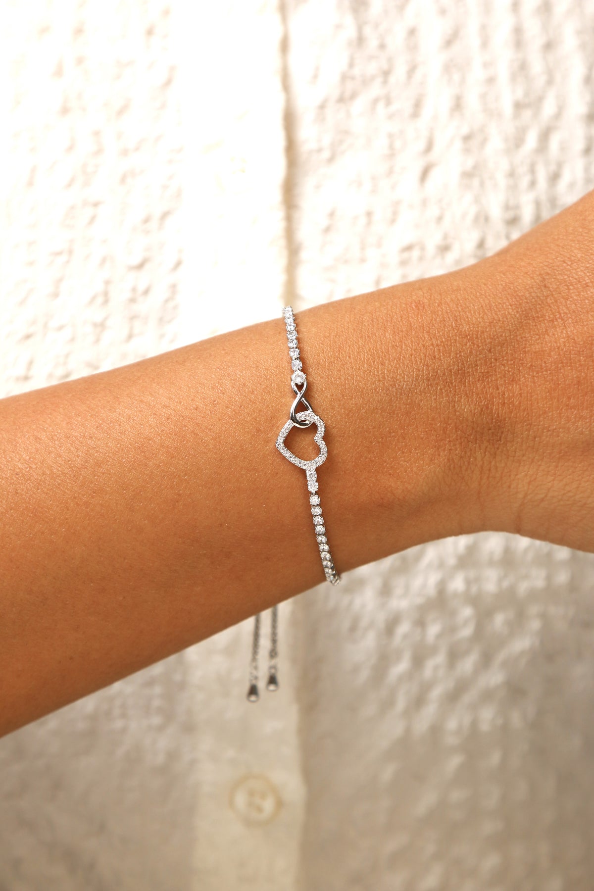Delicate heart charm bracelet with an adjustable chain.