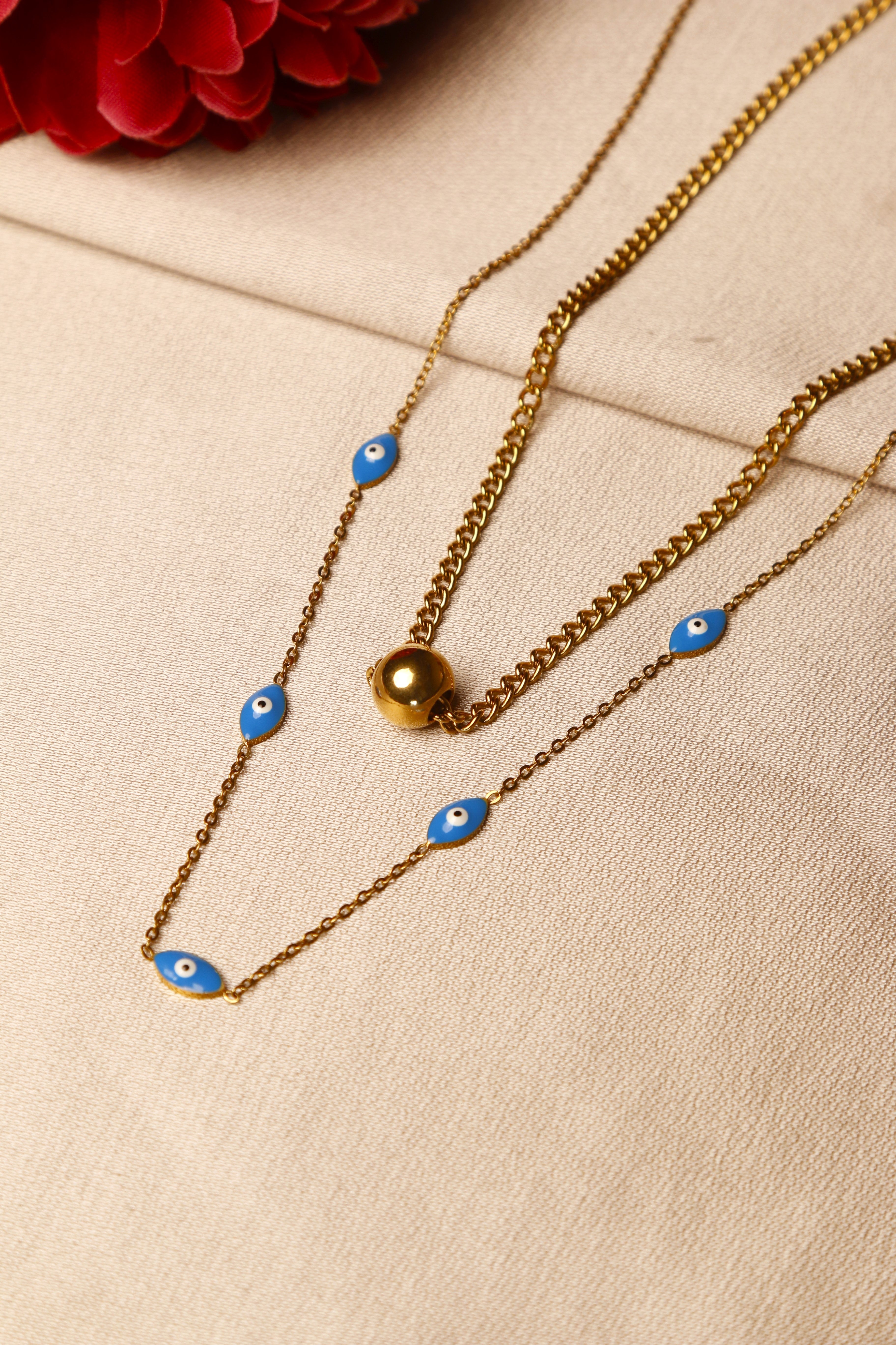 A chic gold necklace with a blue eye charm pendant.