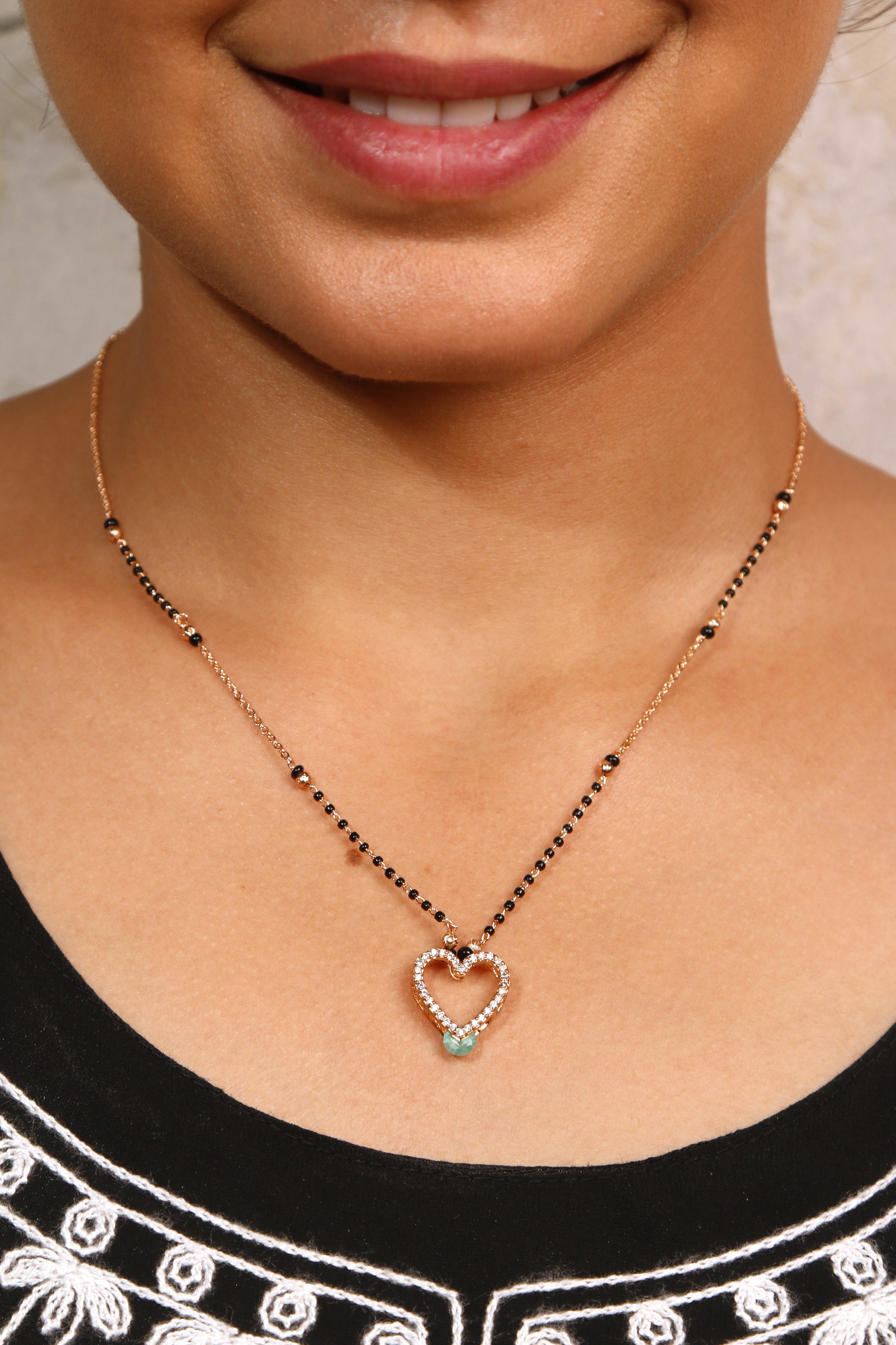 Model wearing a gold heart-shaped mangalsutra
