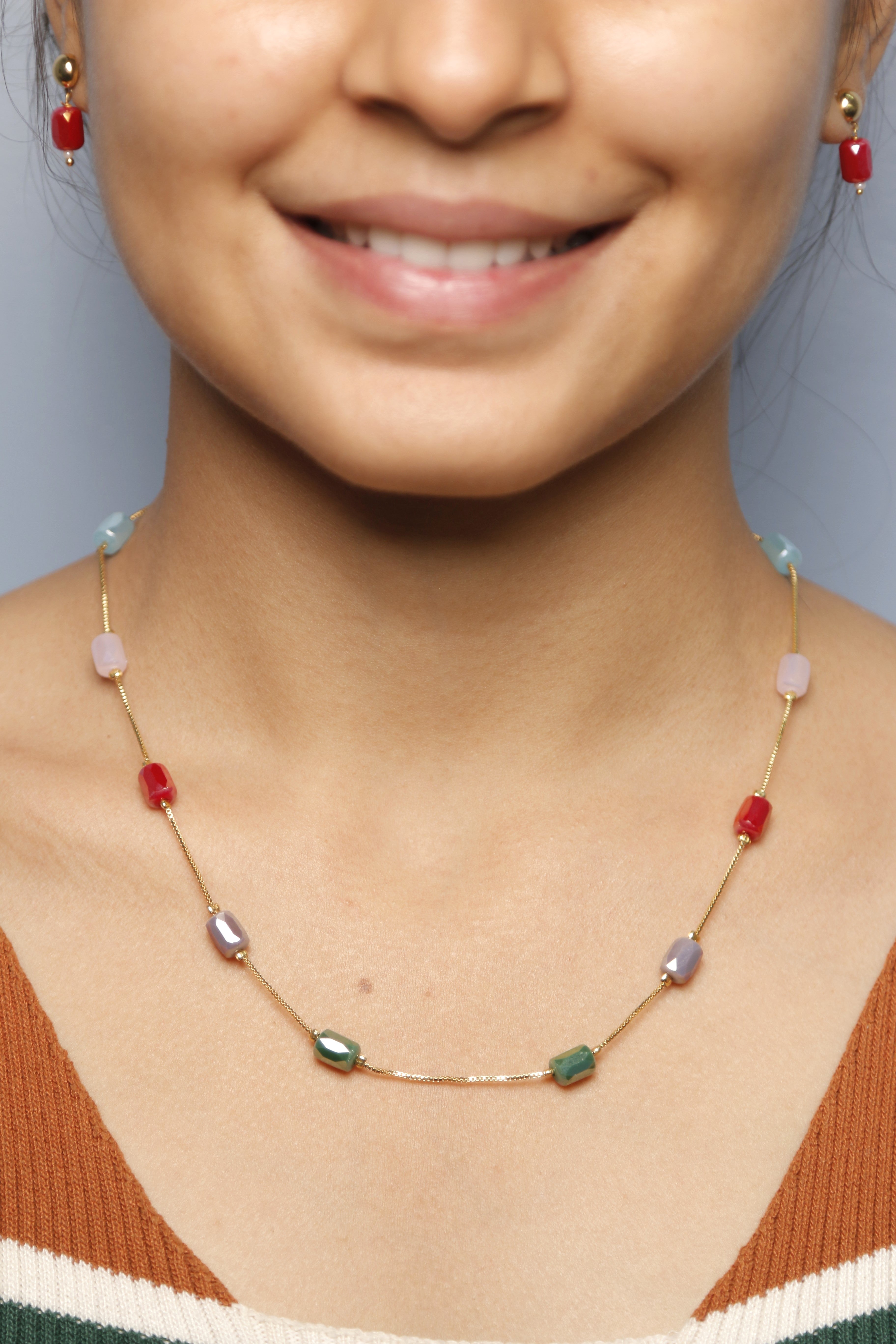 A woman wearing a colorful beaded necklace with various hues.