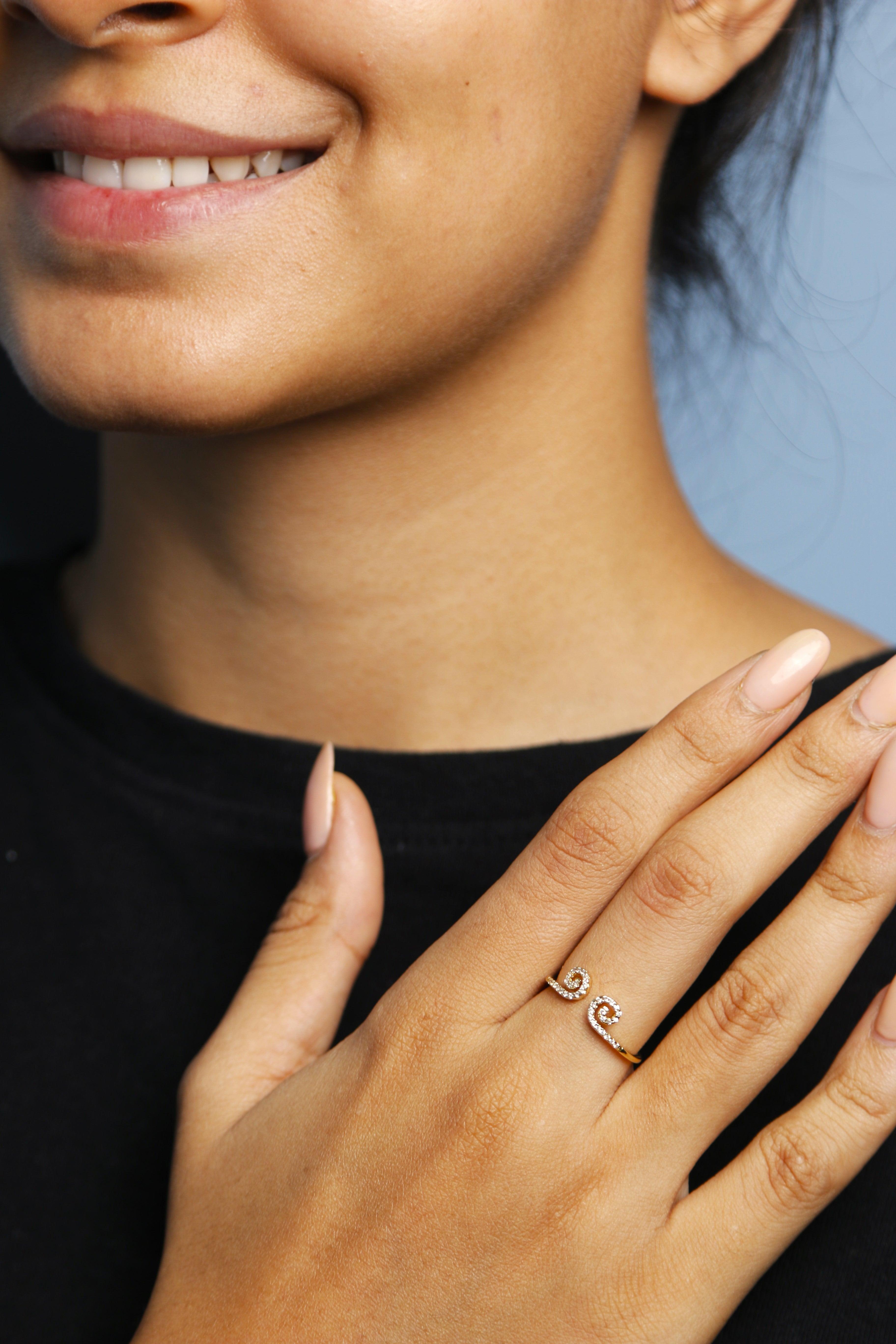 Woman wearing a gold spiral open ring on finger