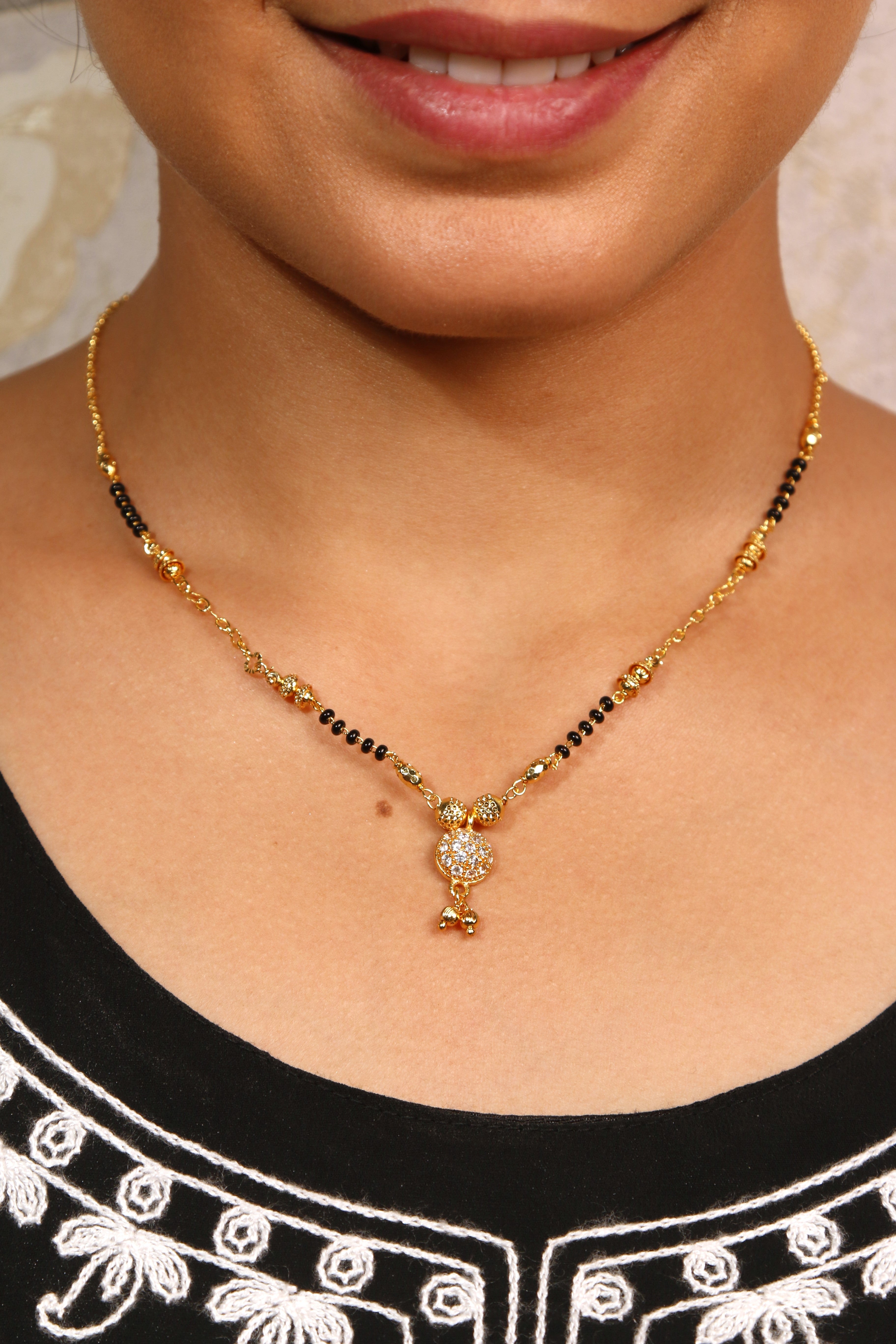 Elegant traditional round diamond mangalsutra design with black beads and gold embellishments.