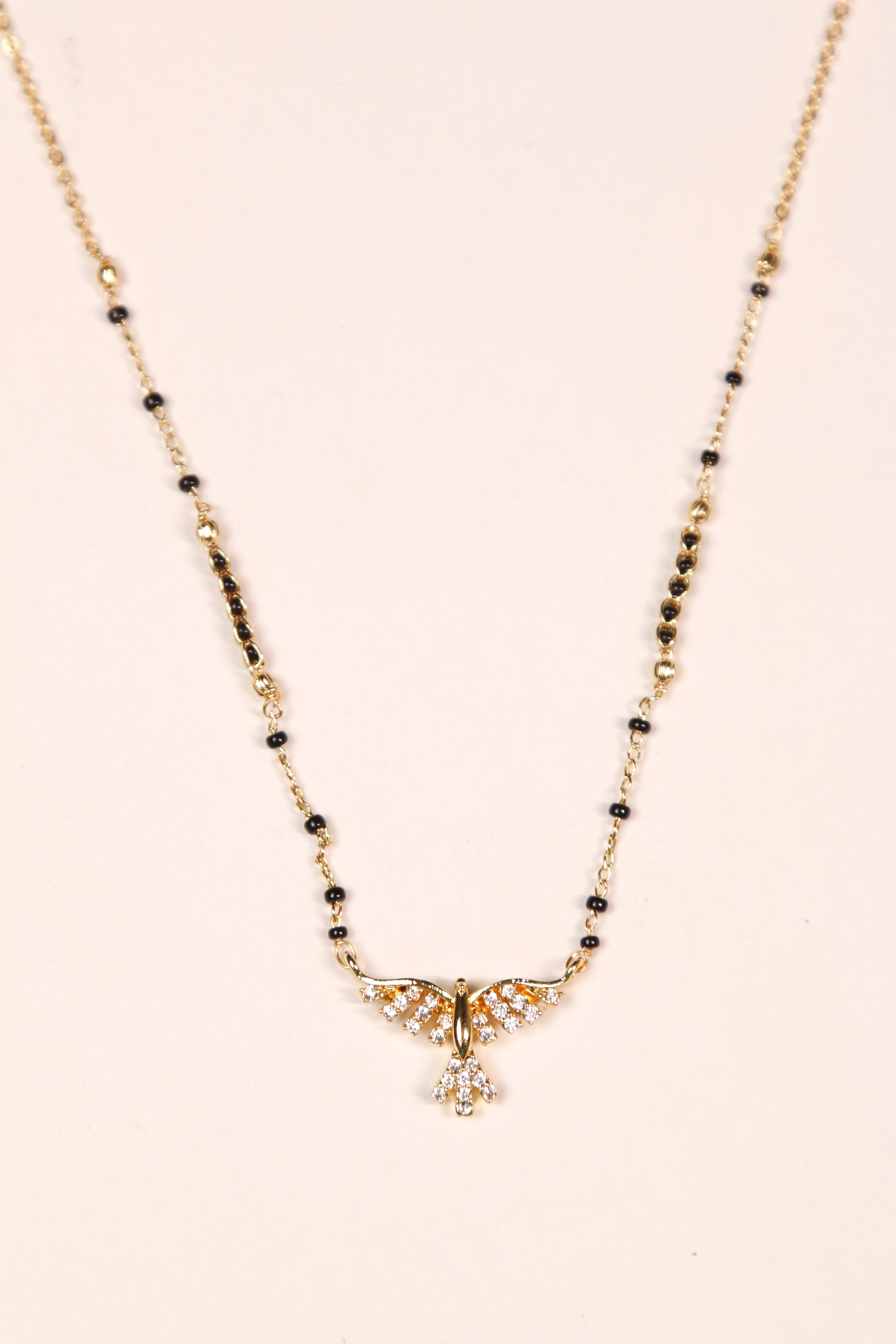 Gold mangalsutra with a wing-like pendant design